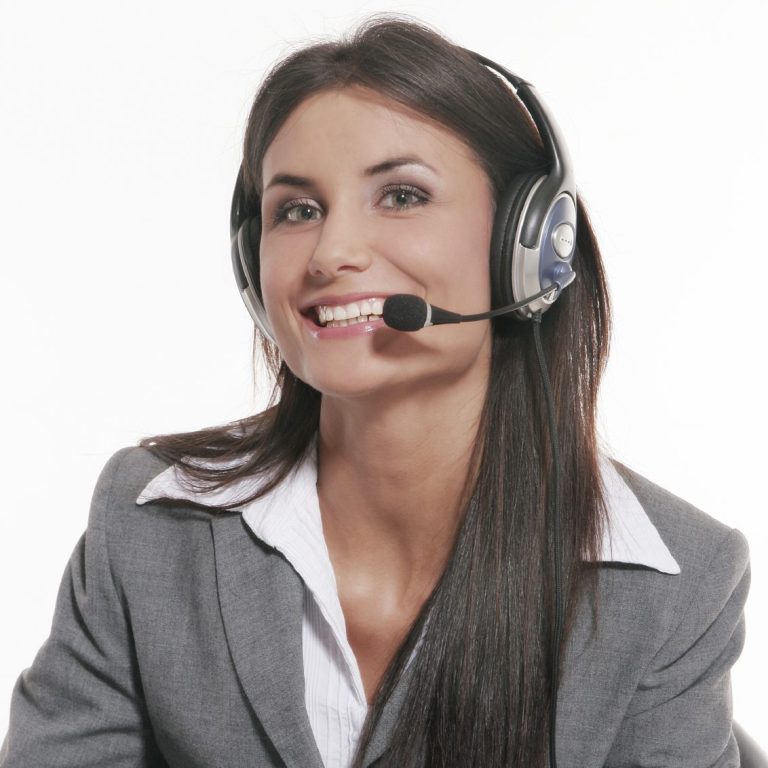 Lächelnde Frau in einem grauen Anzug mit Headset und Mikrofon.
