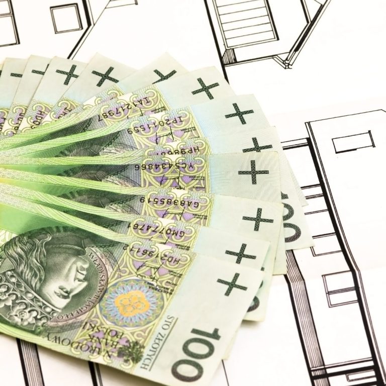 100-Euro-Scheine liegen auf Bauplänen.