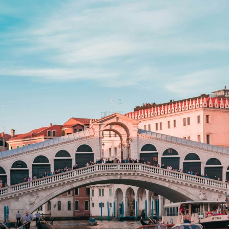 Die Rialtobrücke in Venedig, umgeben von historischen Gebäuden und Wasserwegen.