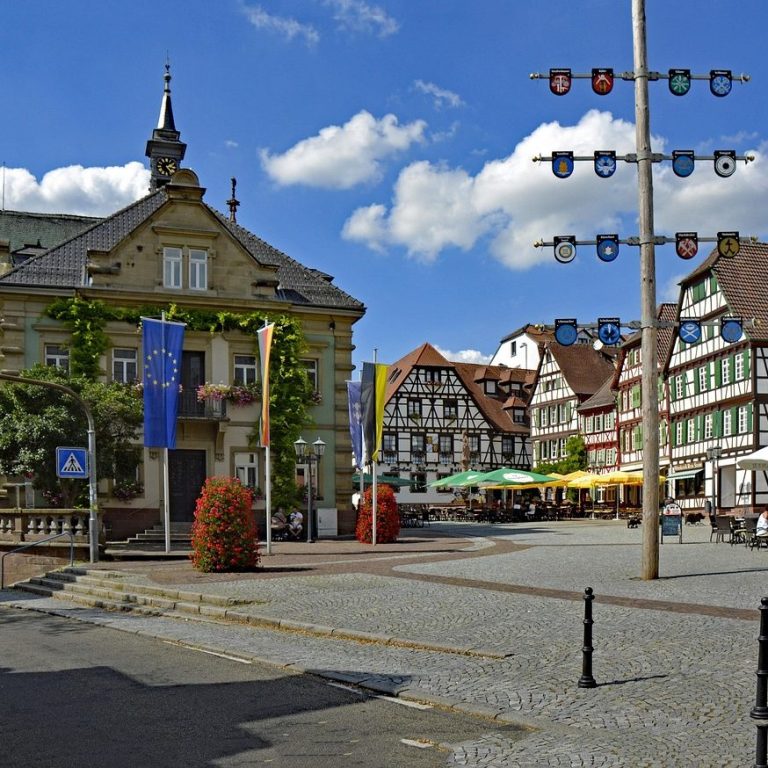 Historischer Marktplatz mit Maibaum und Fachwerkhäusern in einer Kleinstadt in Bretten – Symbolbild für beglaubigte Übersetzungen 