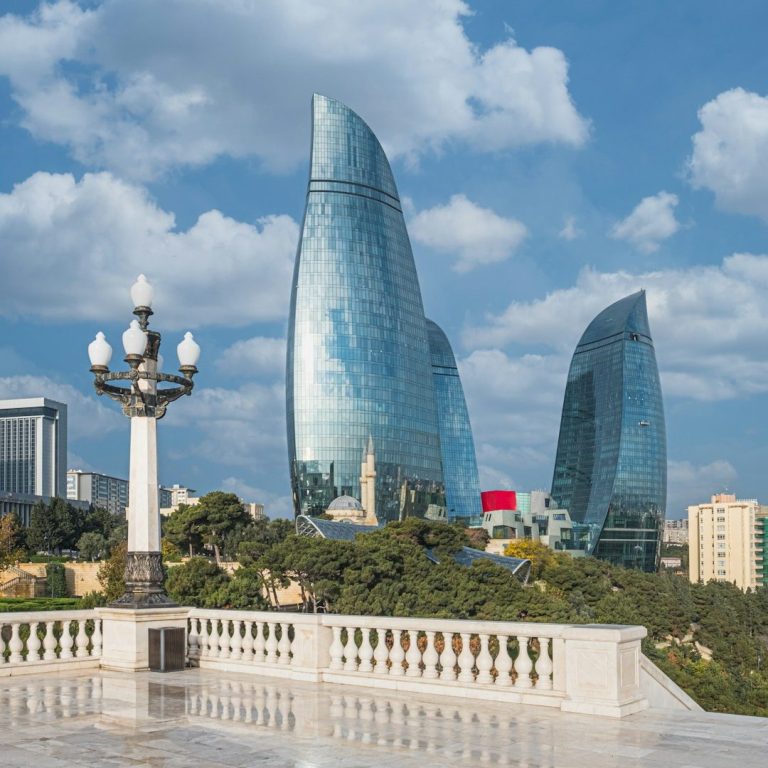 Moderne Gebäude in Baku mit gewölbten Glasfassaden und blauem Himmel.