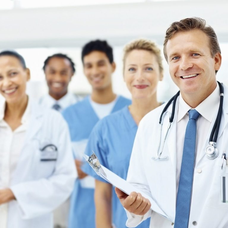 Eine Gruppe von medizinischem Personal lächelt in einer Klinik.