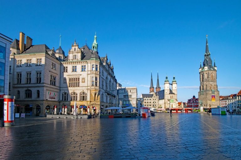 Hanseatische Architektur und historische Türme am Wasser unter klarem Himmel.