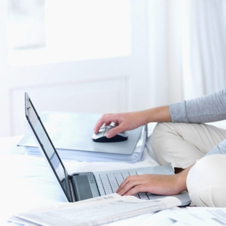 Eine Person nutzt einen Laptop und eine Computermaus im Innenraum.