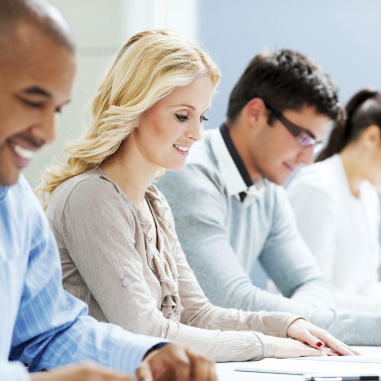 Mehrere Personen arbeiten konzentriert an Tischen in einem modernen Büro.