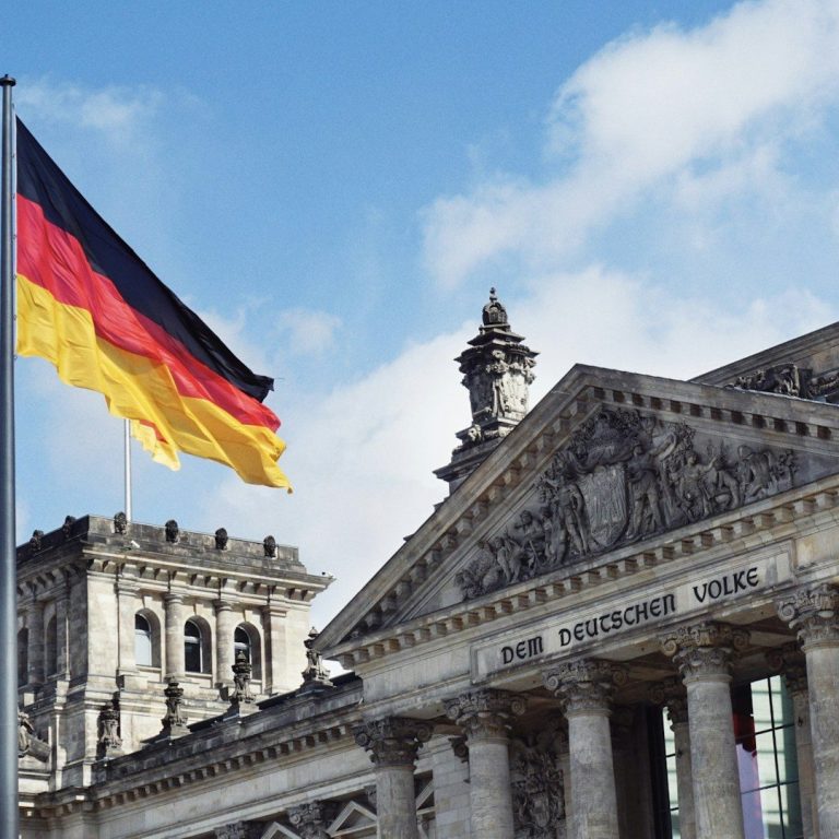 Deutsche Flagge vor dem Reichstagsgebäude in Berlin – Symbol für amtlich anerkannte Übersetzungen in Deutschland